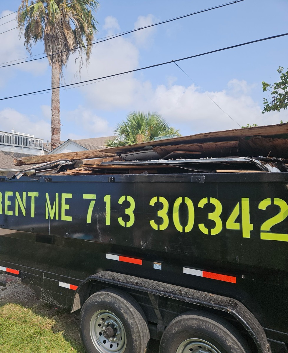 Close-up of lumber and roofing debris in the trailer