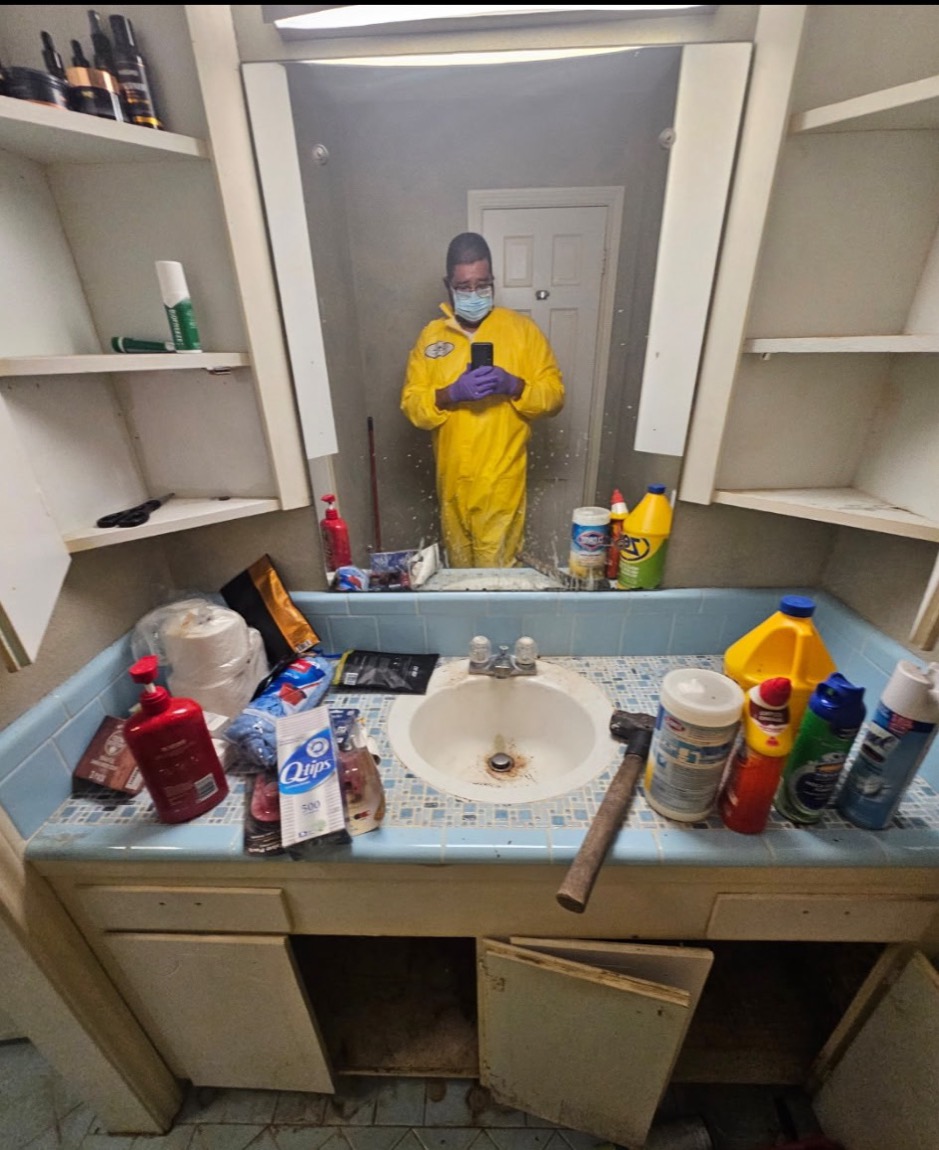 Crew member in protective suit during a bathroom cleanout