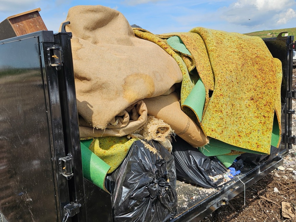 Trailer full of torn-out carpet and pad at the landfill